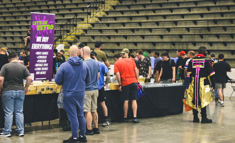 Attendees browsing exhibitor booths at an indoor event, representing a careers fair