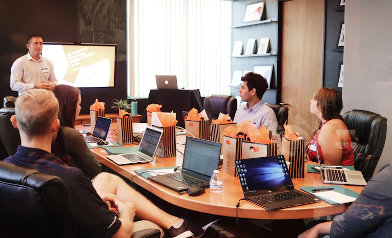 Young professional presenting to colleagues in an office meeting, representing UK graduate schemes