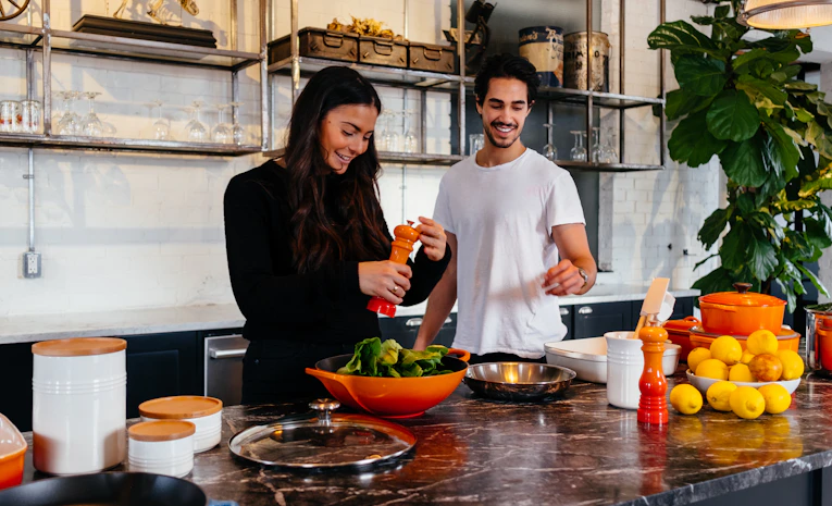 Two people cooking together in a kitchen, representing living with flatmates
