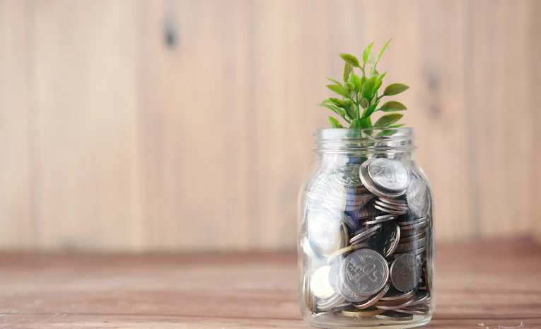 Glass jar filled with coins, representing student budgeting