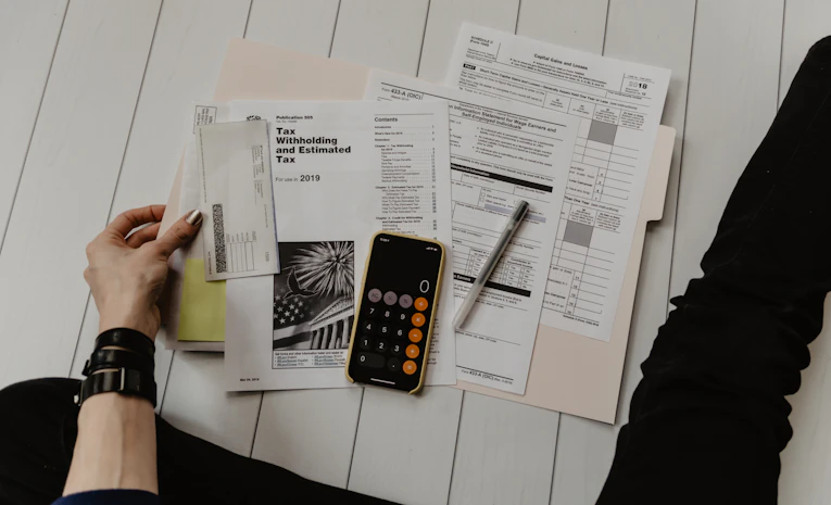 Person calculating budget with paper and calculator, representing UK student finance planning