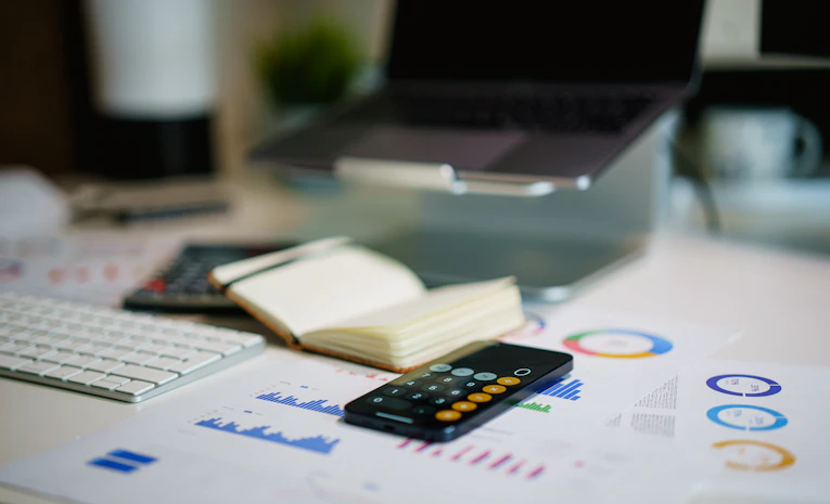 Desk with financial charts and smartphone, representing student loan repayment planning