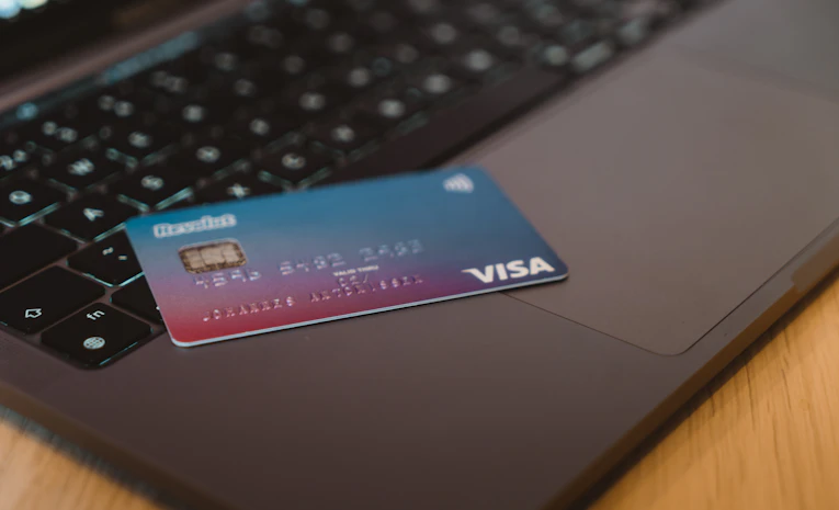 Debit card resting on a laptop keyboard, representing a student overdraft account