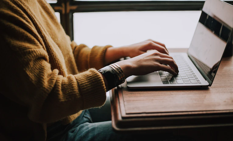 Person sitting in front of a laptop, representing checking a UCAS Extra application