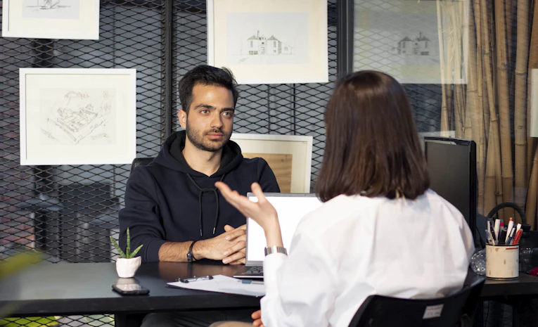 Person talking across a desk during a formal interview, representing university interview tips