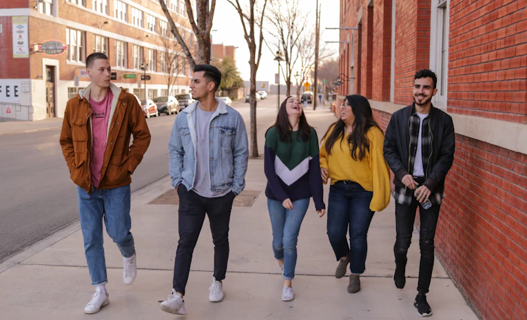 Group of young people walking and talking together outdoors, representing a university open day